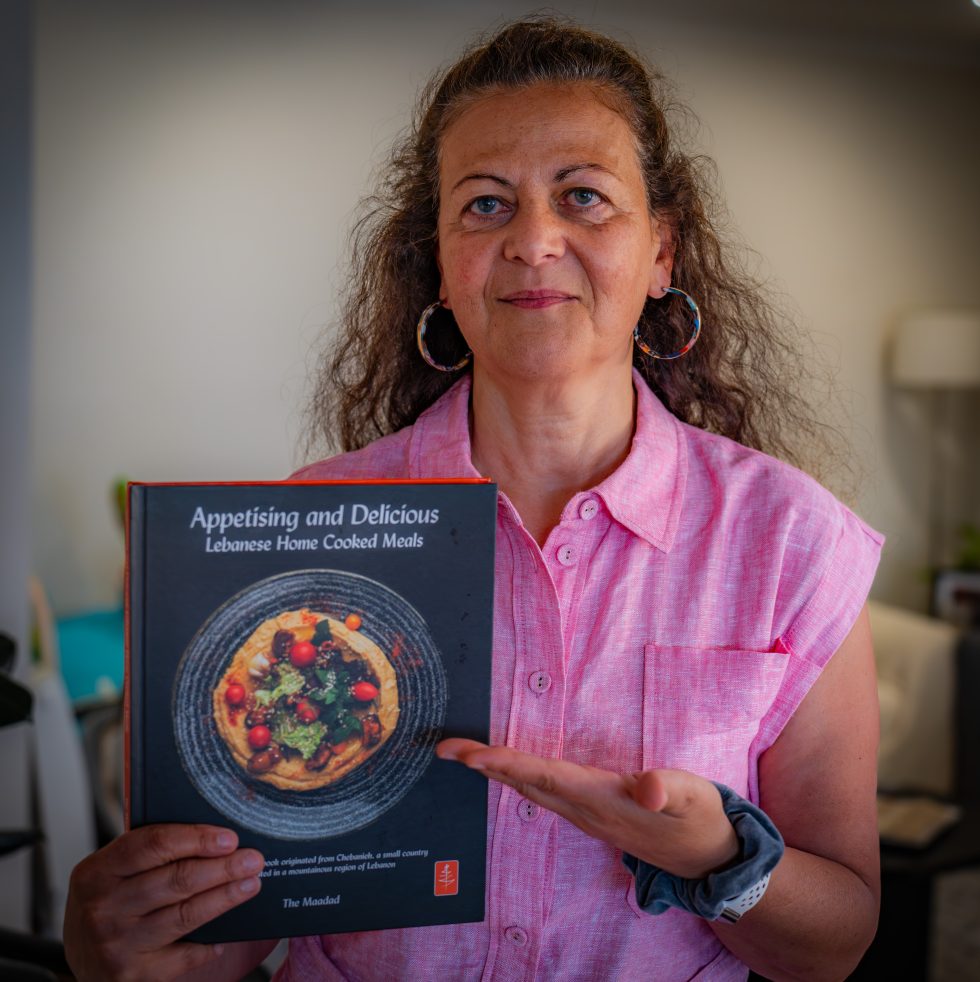 Nina Maadad holding the Appetising and Delicious cookbook